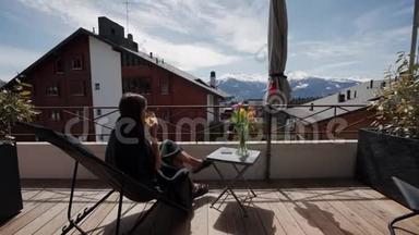 年轻女子在阳台上<strong>喝果汁</strong>，在背景上<strong>喝</strong>雪山。 假期和放松